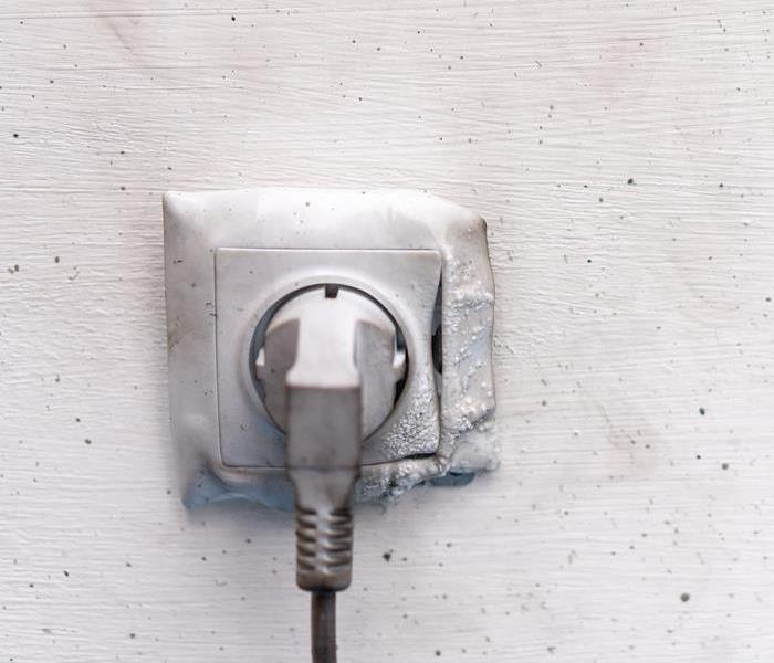 Melted plastic surrounds a wall outlet