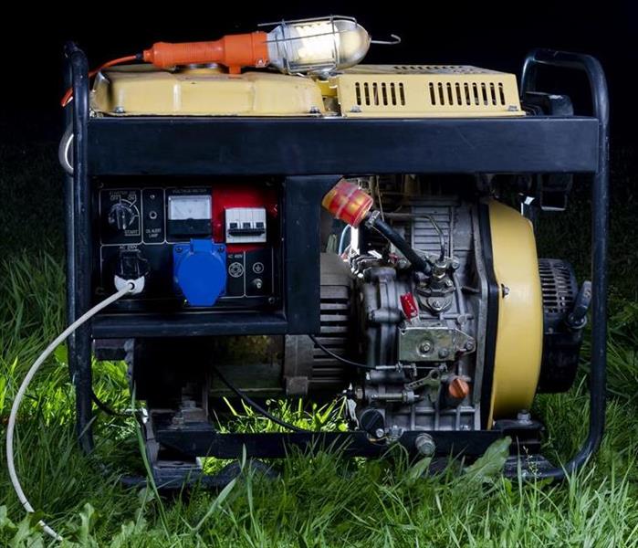 A portable gas generator sits in a grassy area.